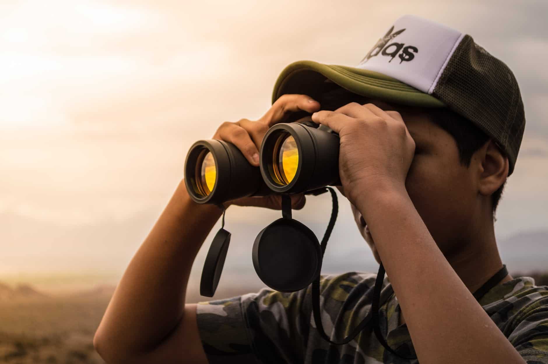 Young man using black binoculars